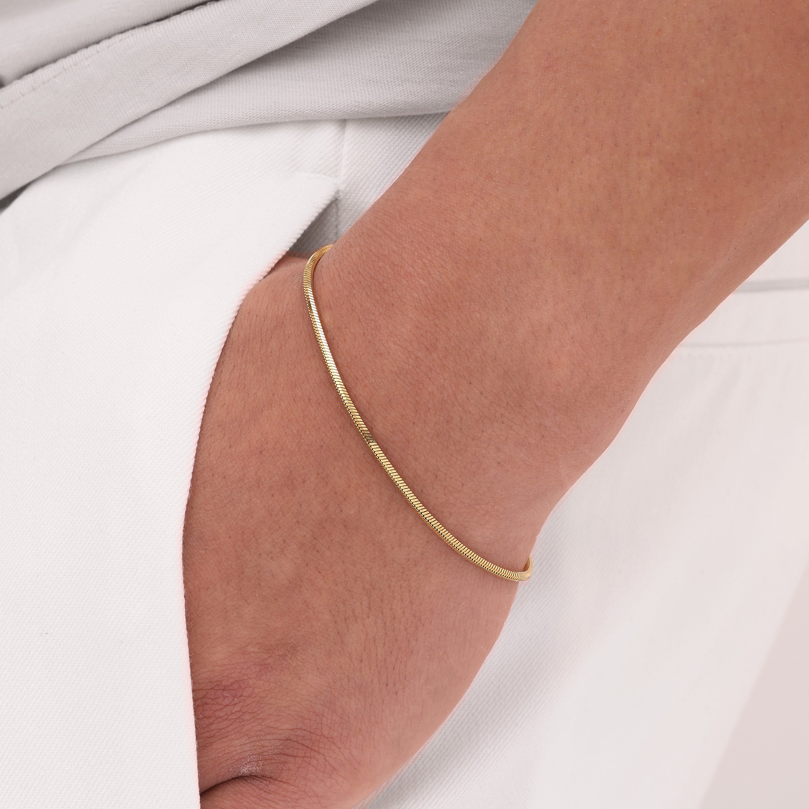 Gold snake bracelet on a wrist