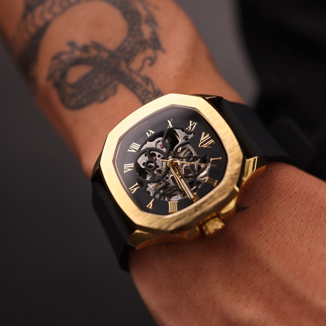 man wearing skeleto gold and black watch