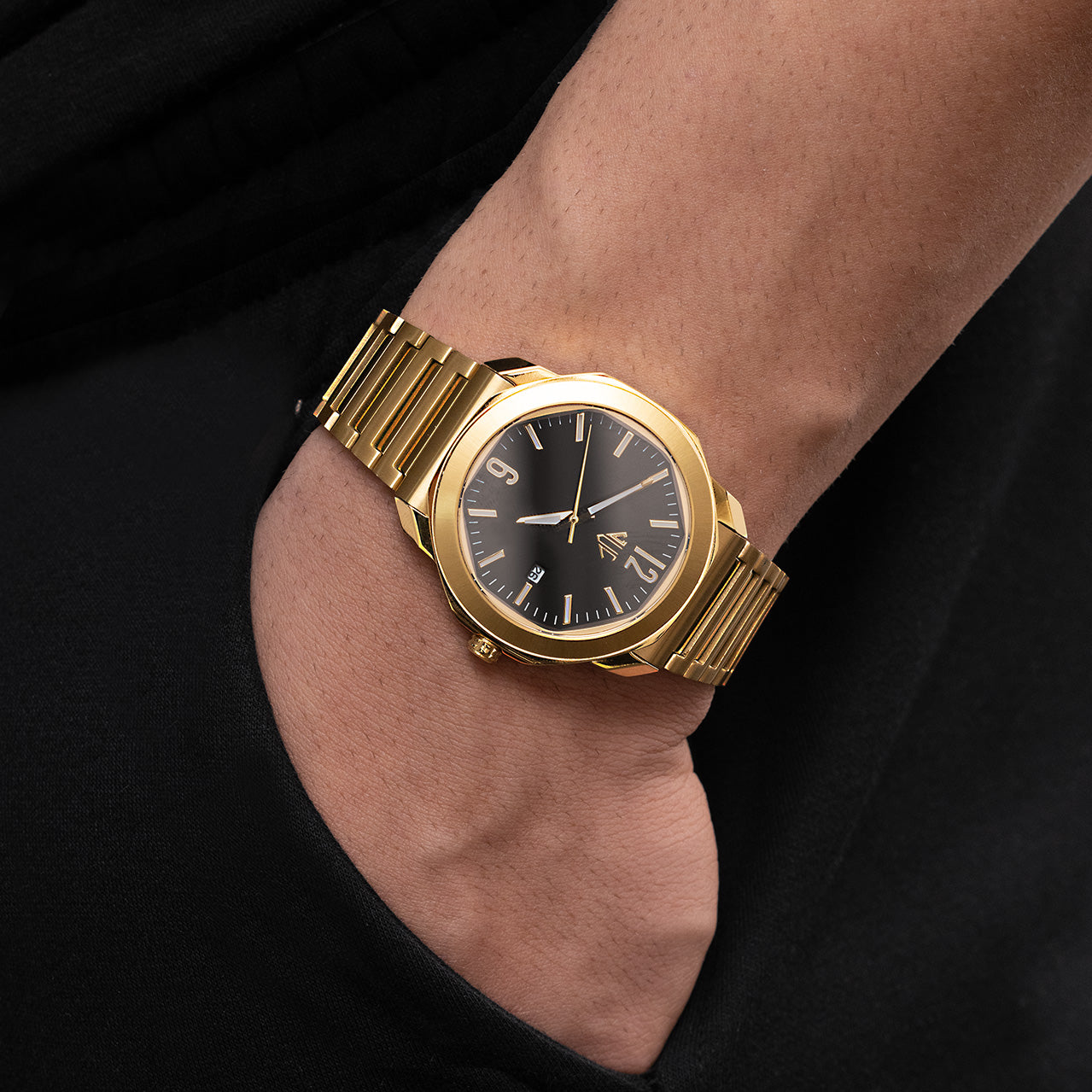 Gold wristwatch on a person's wrist with a black background