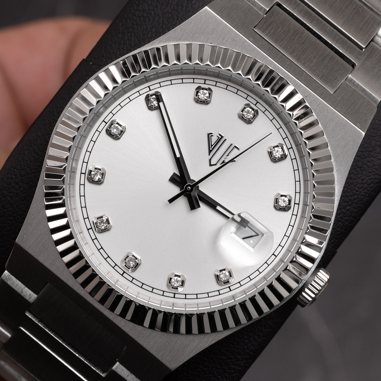 Silver watch with diamond-studded face on a dark background