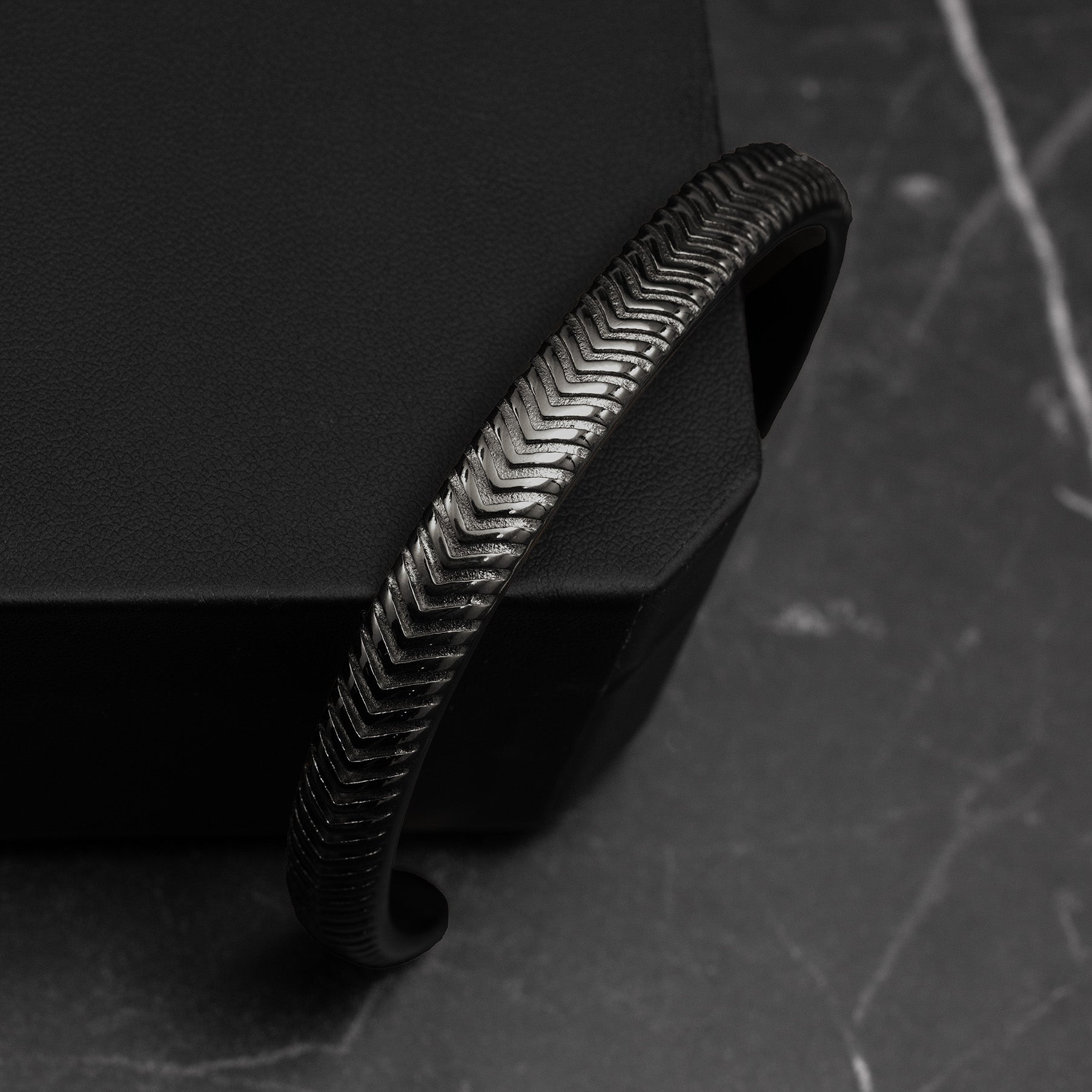 Black textured bracelet on a dark surface