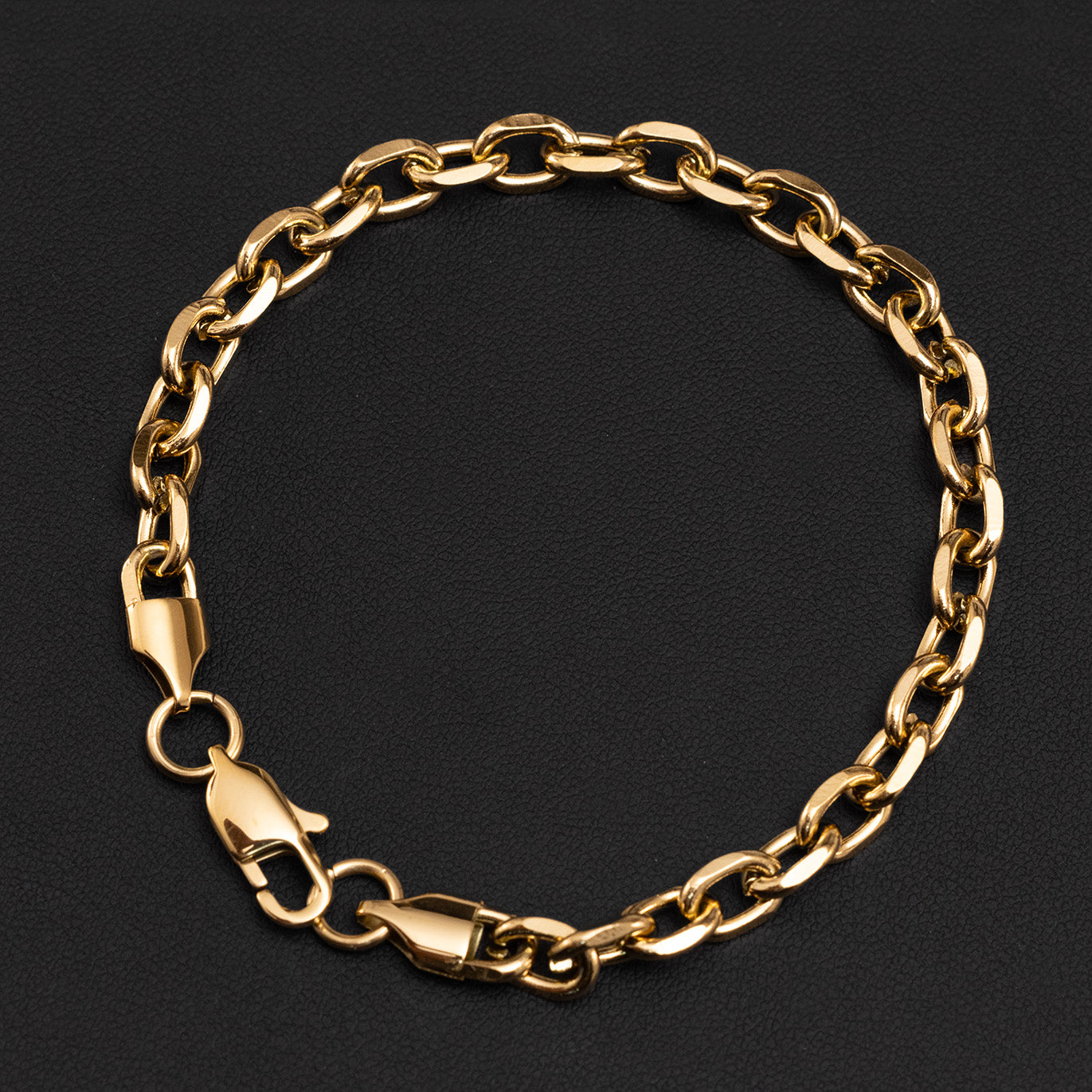 Gold plated chain bracelet on a black background