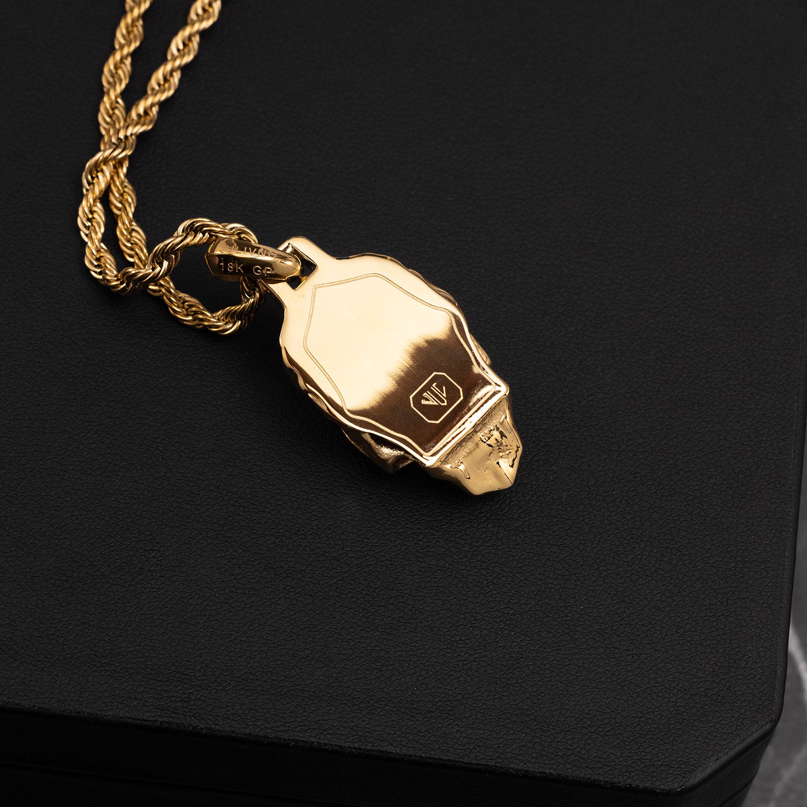 Gold necklace with a pendant on a black background