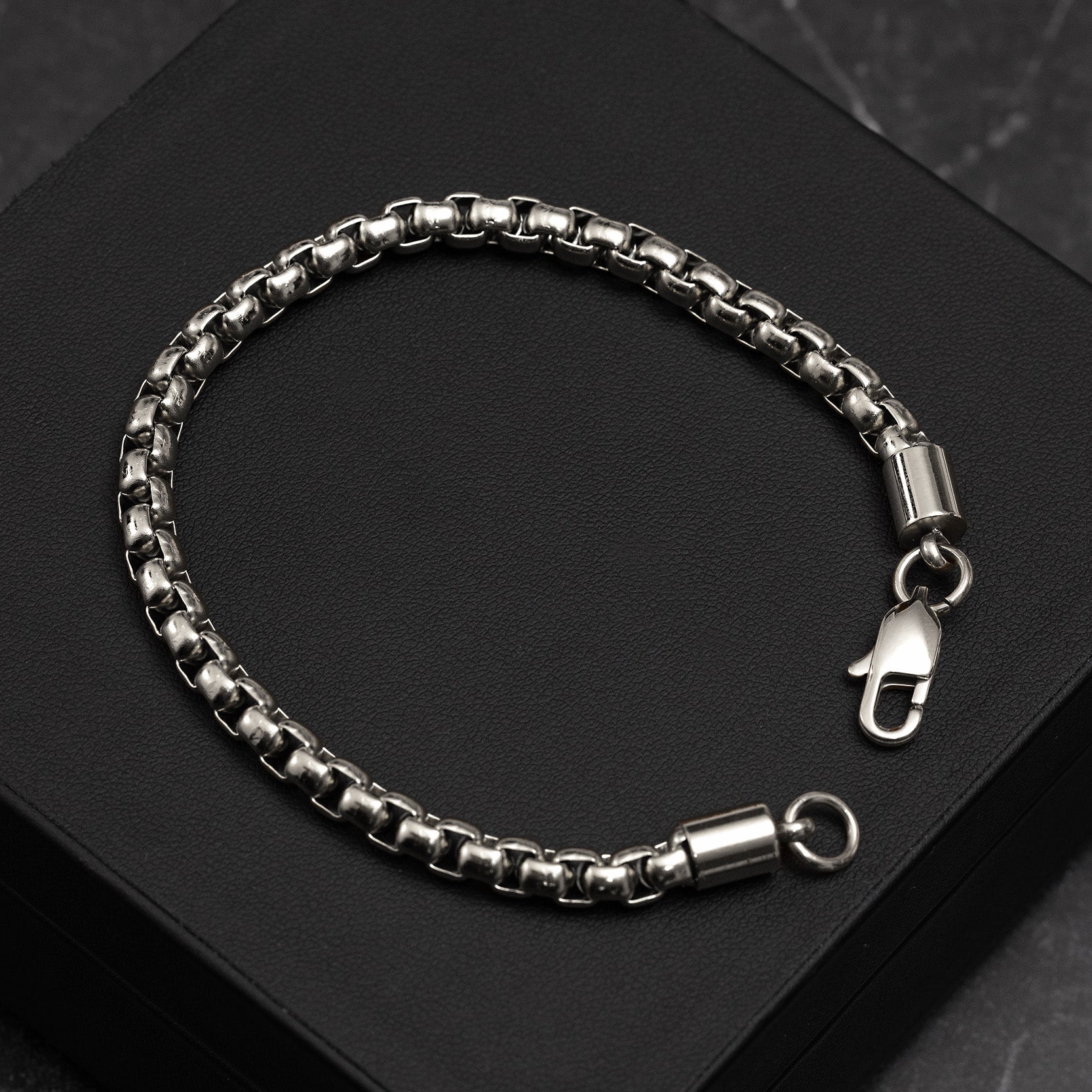 Silver chain bracelet on a black surface