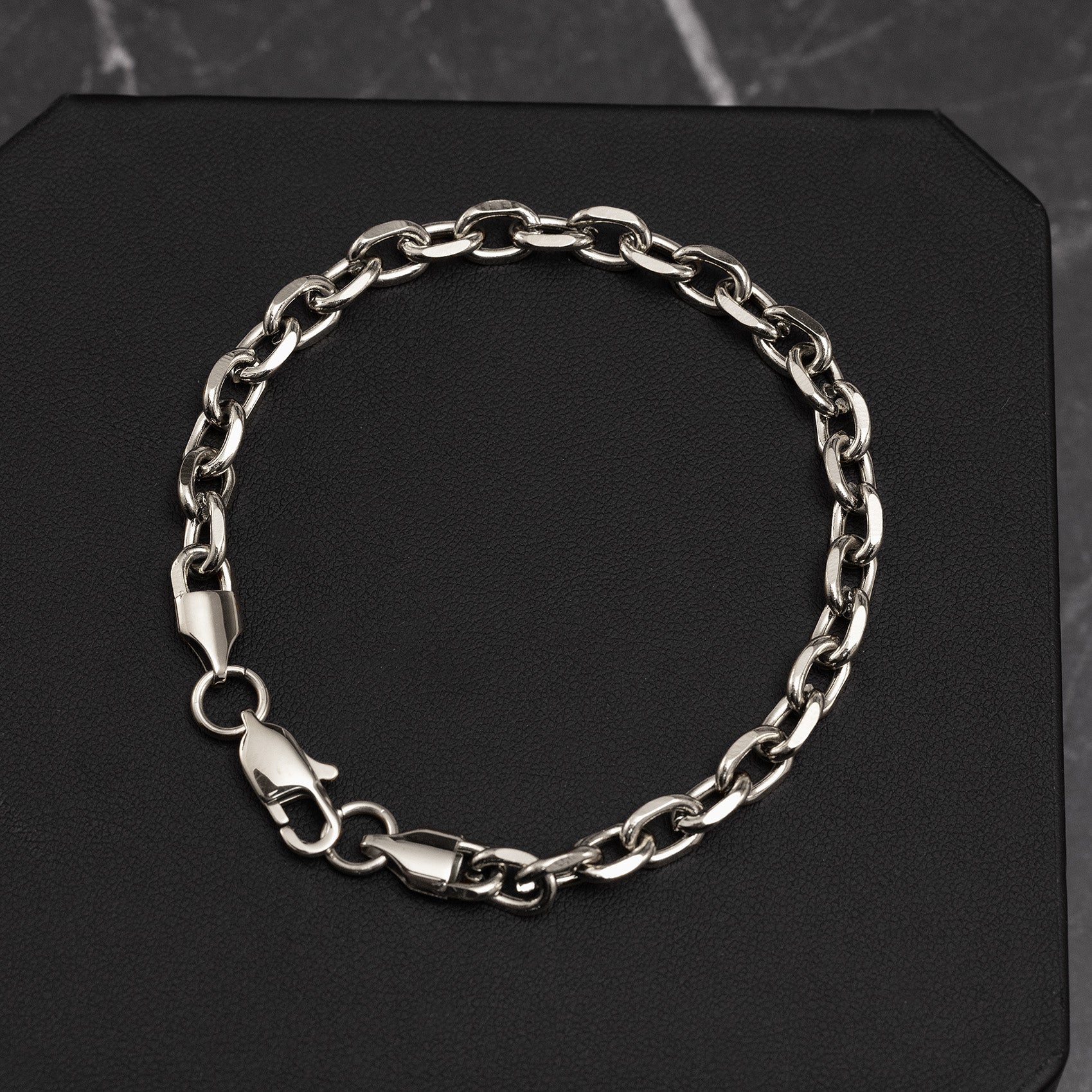 Silver chain bracelet on a black background