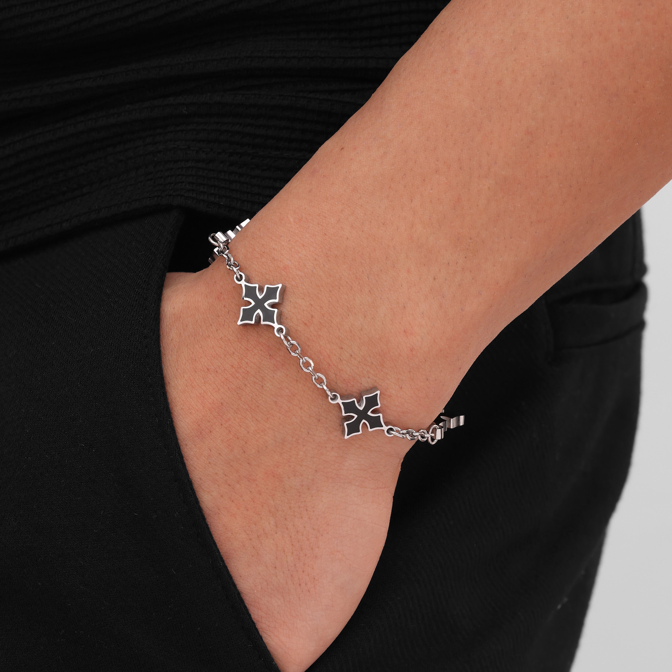 Silver bracelet with crosses charms on a wrist 